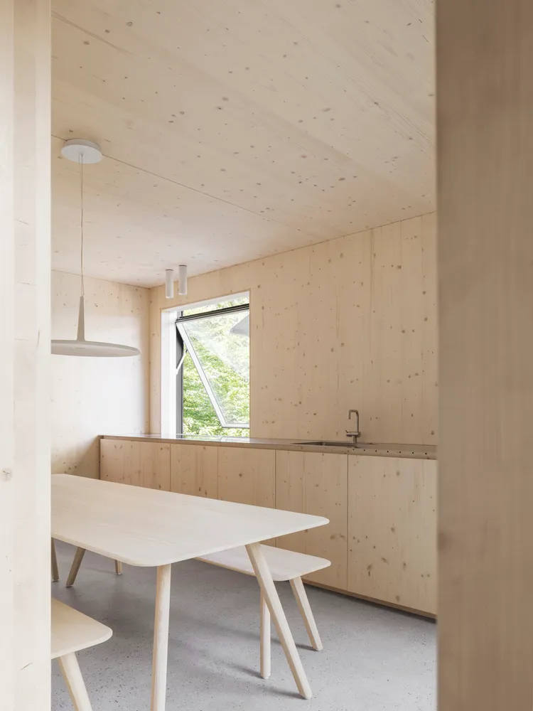 A minimalist kitchen with wooden elements and a large window