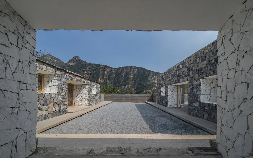 現代建築室內空間,融合石材外觀與山景中的中央花園。