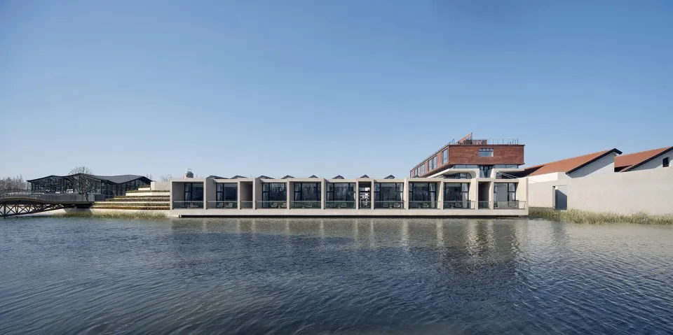 Modern waterfront retreat featuring brick and concrete structures with glass elements.