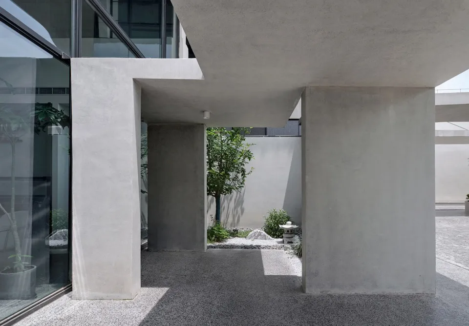 Modern minimalist architecture with concrete structures and a central courtyard.