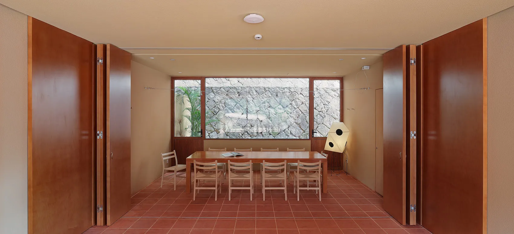 Conference room with minimalist design featuring wood and stone materials.