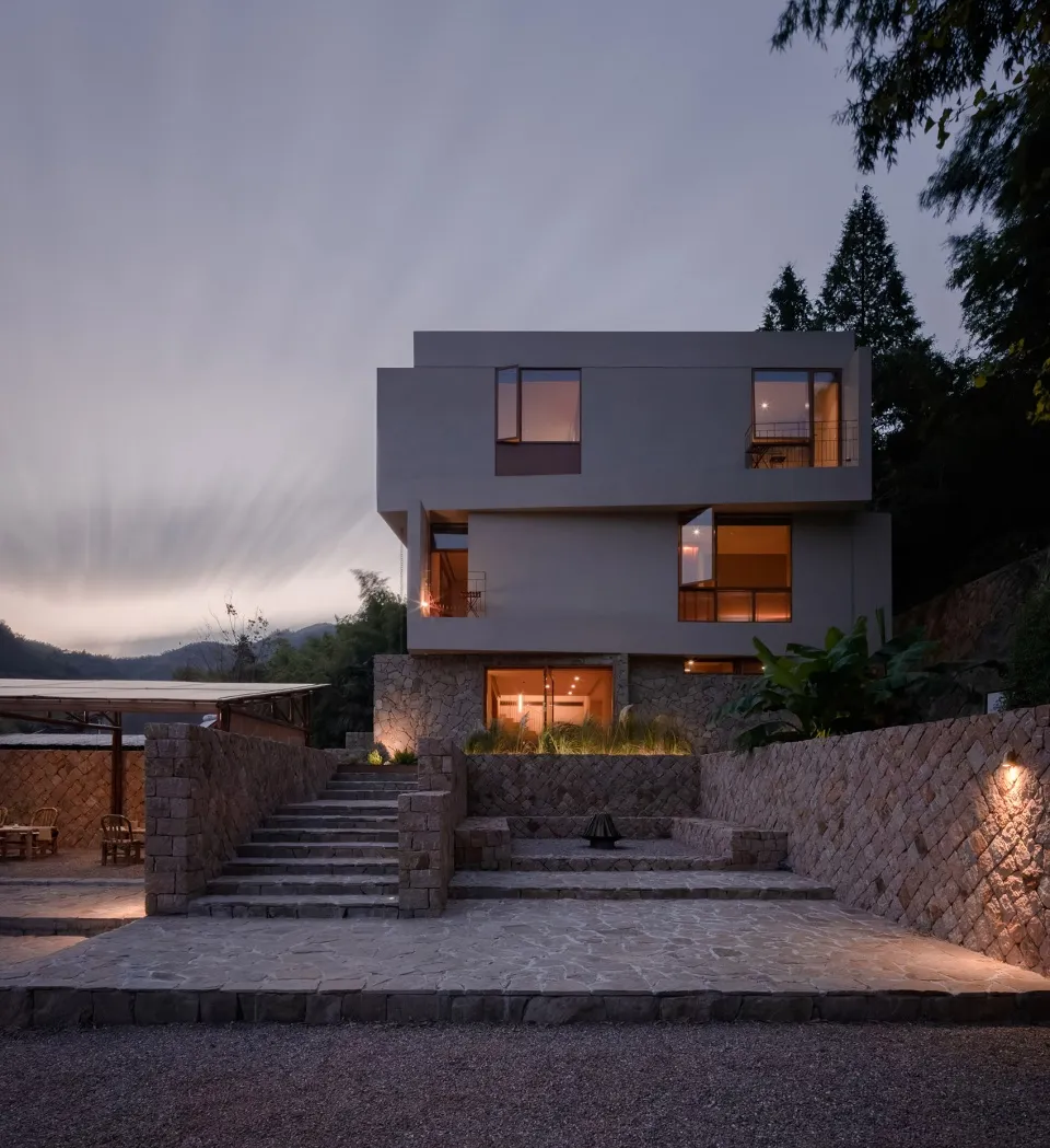 A modern residential home with concrete, stone, and glass materials.