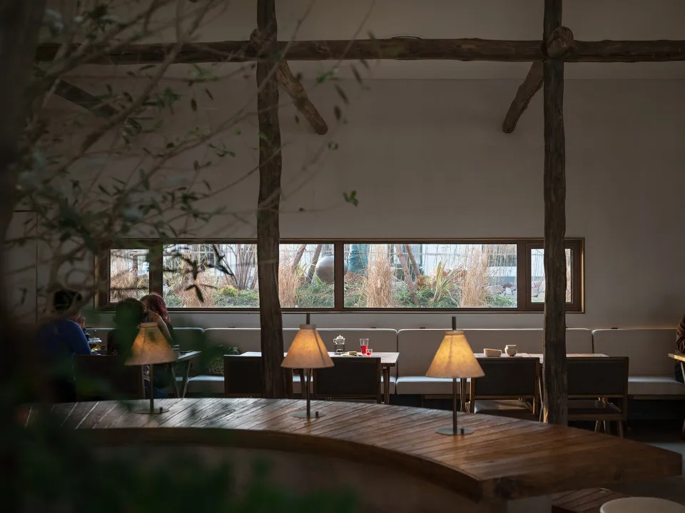 Interior design of a restaurant with industrial style elements such as wood, fabric, and glass.