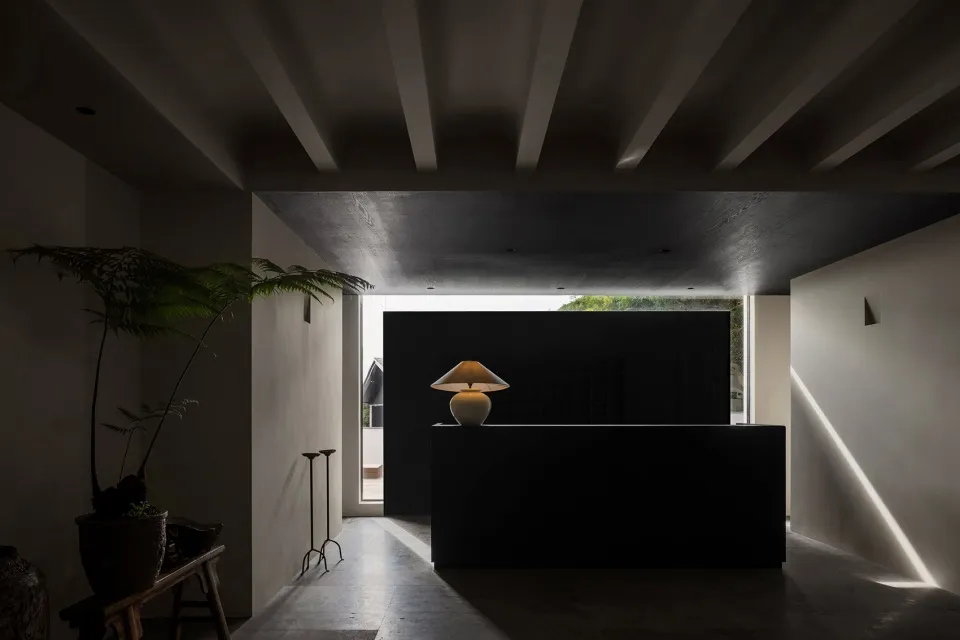 A modern black office space with a concrete interior and a black reception desk.
