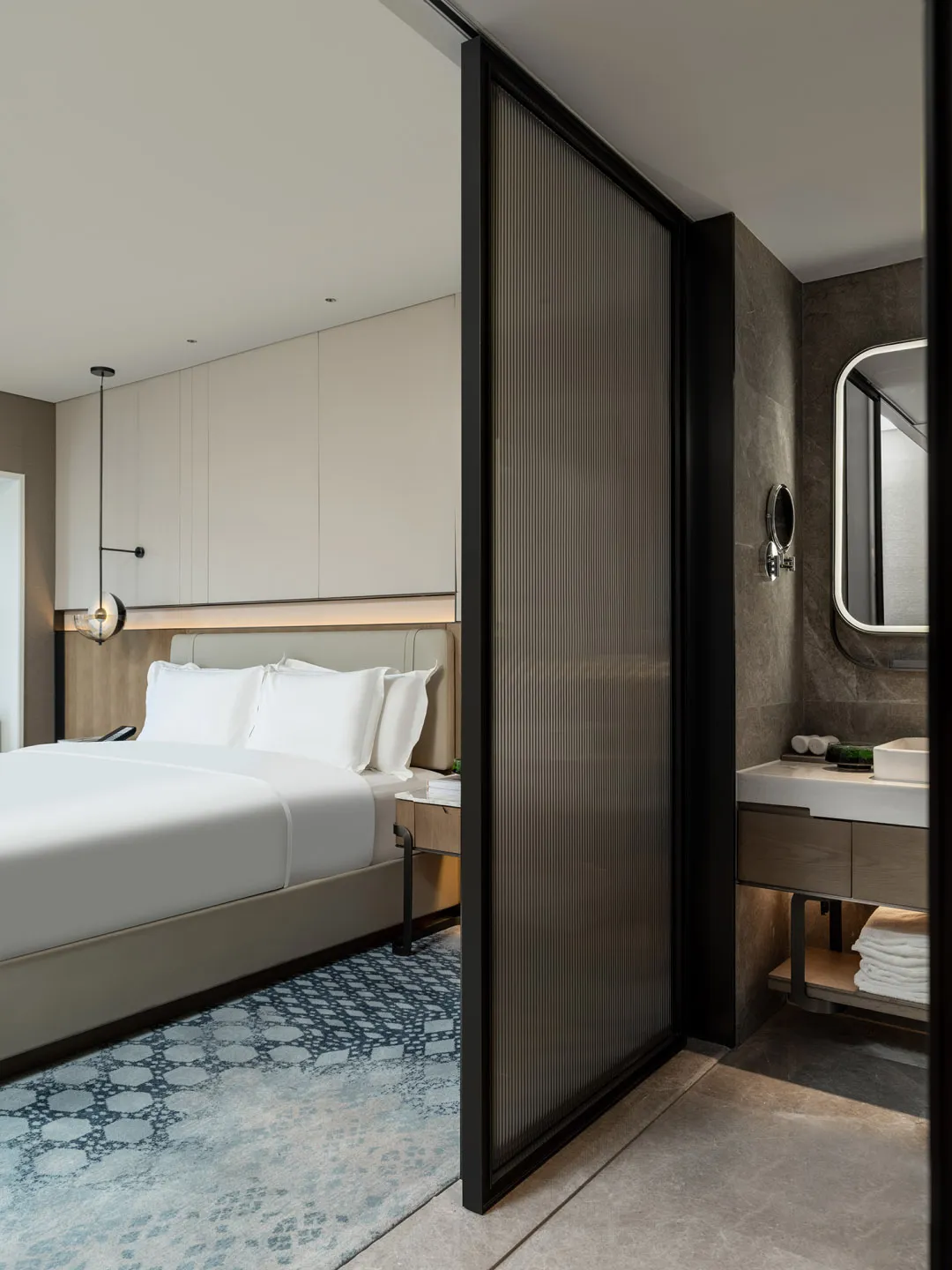 A modern minimalist bedroom featuring neutral tones and clean lines, showcasing a comfortable yet stylish space.