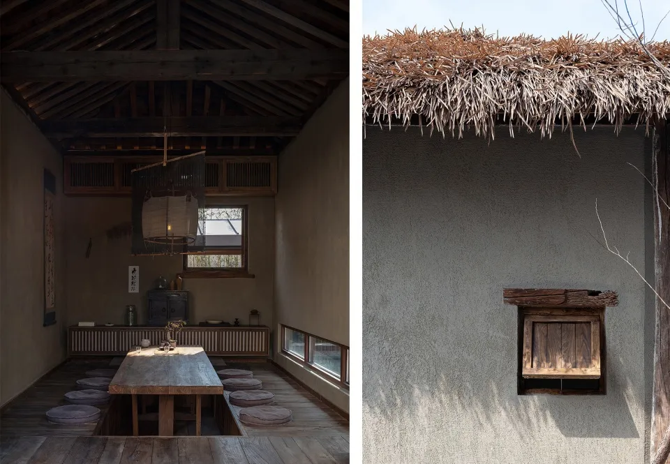 A rustic living room with wooden furniture, a thatched roof, and concrete walls.