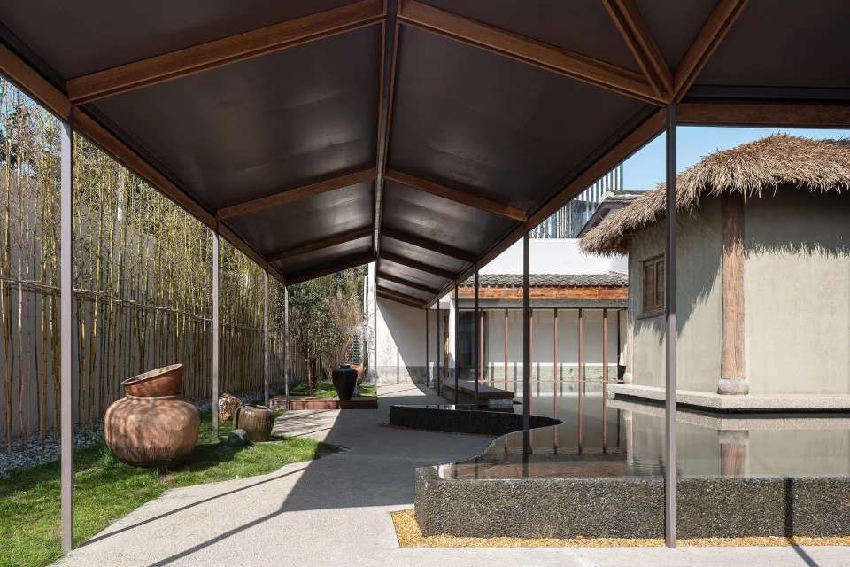 Outdoor space with modern minimalist design features comprising concrete, stone, and wooden elements.