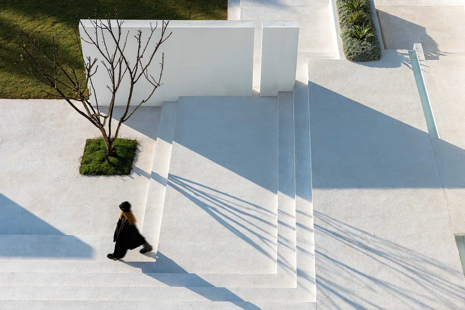 A modern exterior space with white concrete steps and surrounding concrete patio.
