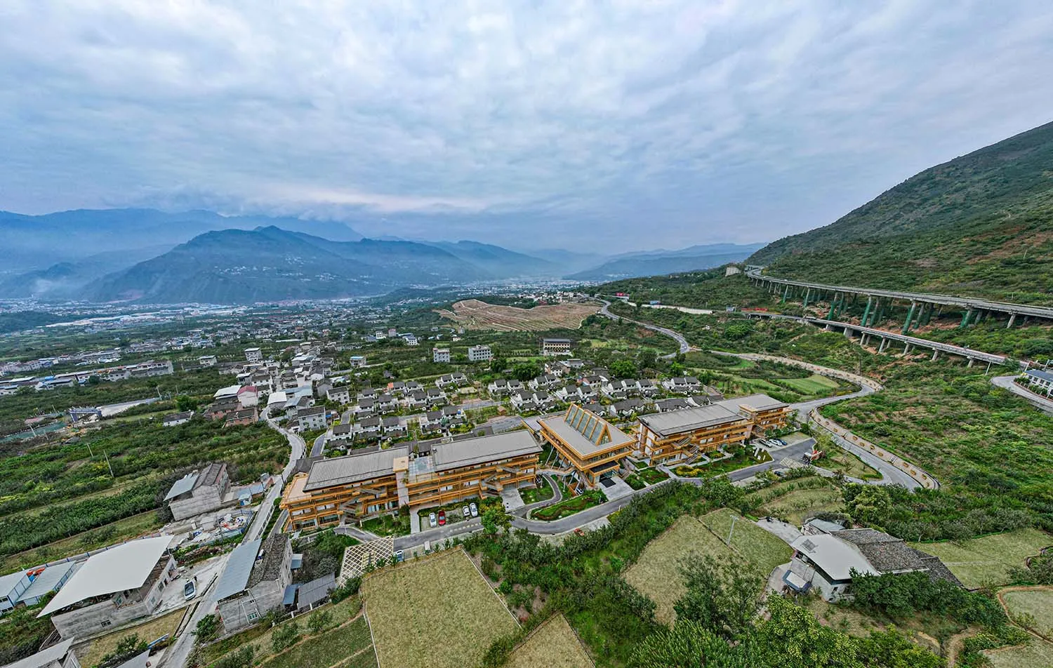 Aerial view of a mountain town with modern buildings and natural surroundings.