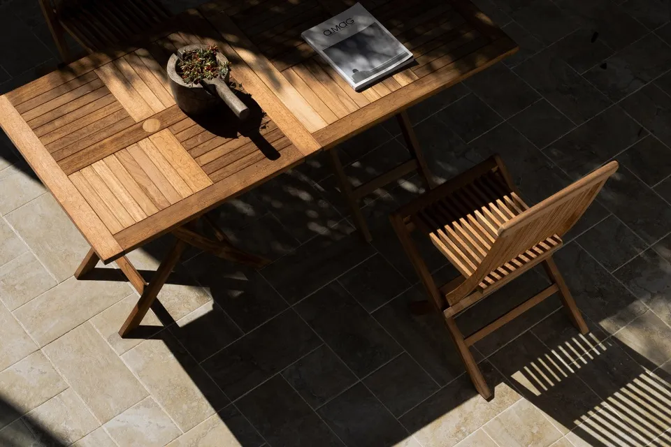 A wooden table and chair set with a magazine and a mortar and pestle.