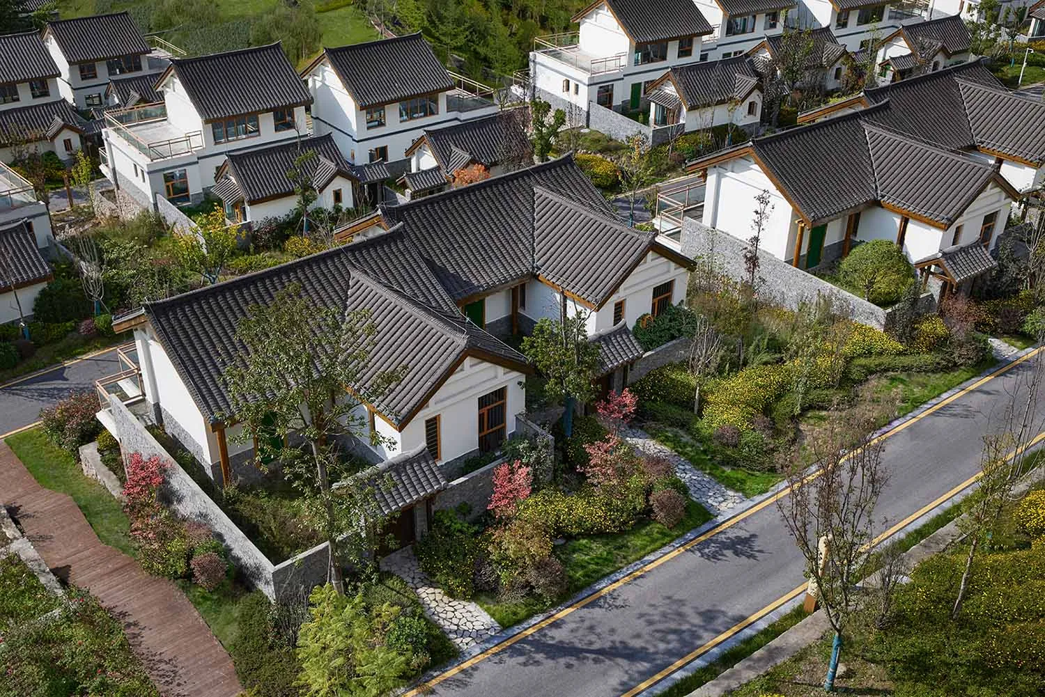 Residential front yard with white stone walkway, terracotta tiles on roof, and concrete curbs.
