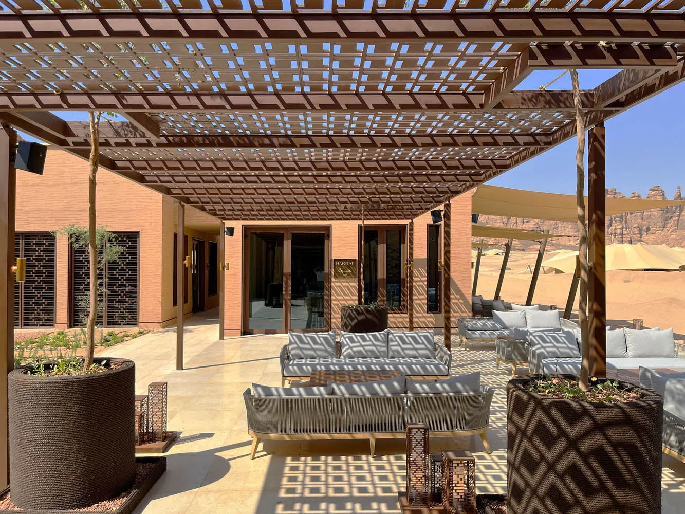 Luxurious patio area with minimalist design featuring concrete, glass, and metal materials.