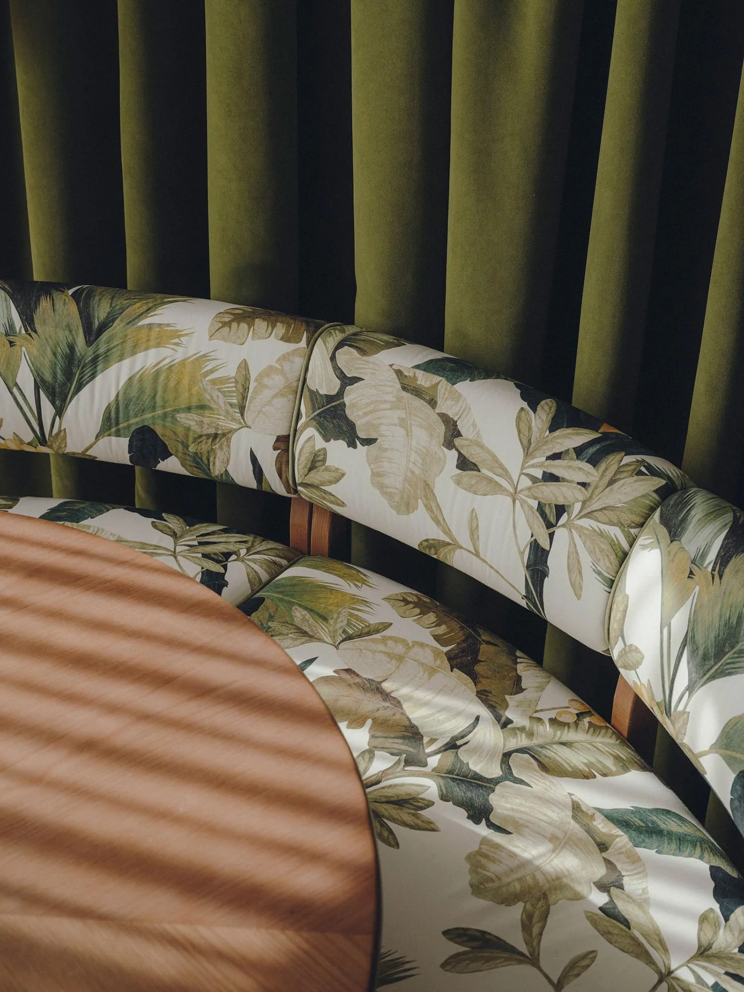 Modern dining room furniture featuring a botanical print upholstery and a wooden table.