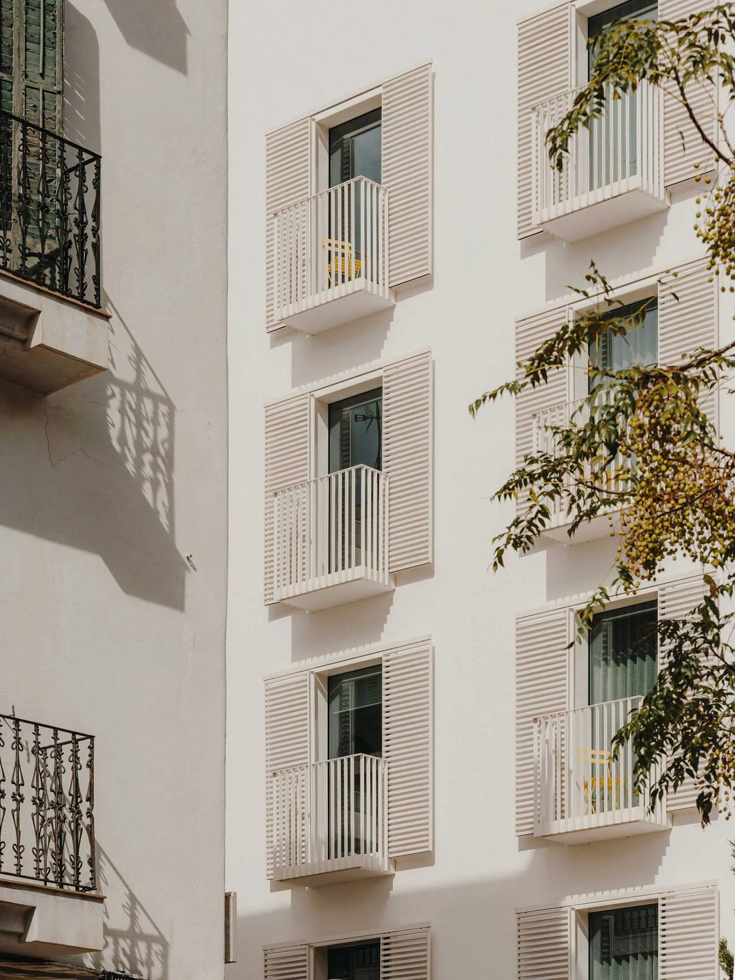 Modern buildings with white painted exteriors, metal shutters, and concrete foundations.