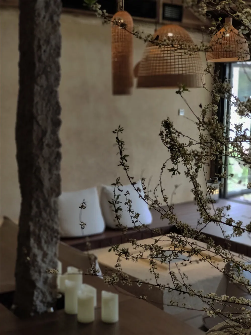 Living room with wooden furniture, cushions, and floral decor.