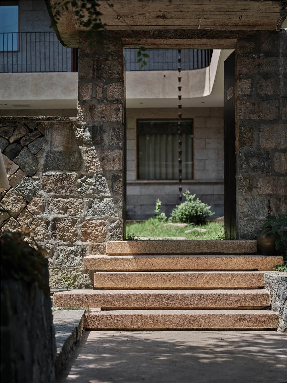 A stone entrance with steps leading up to a doorway.
