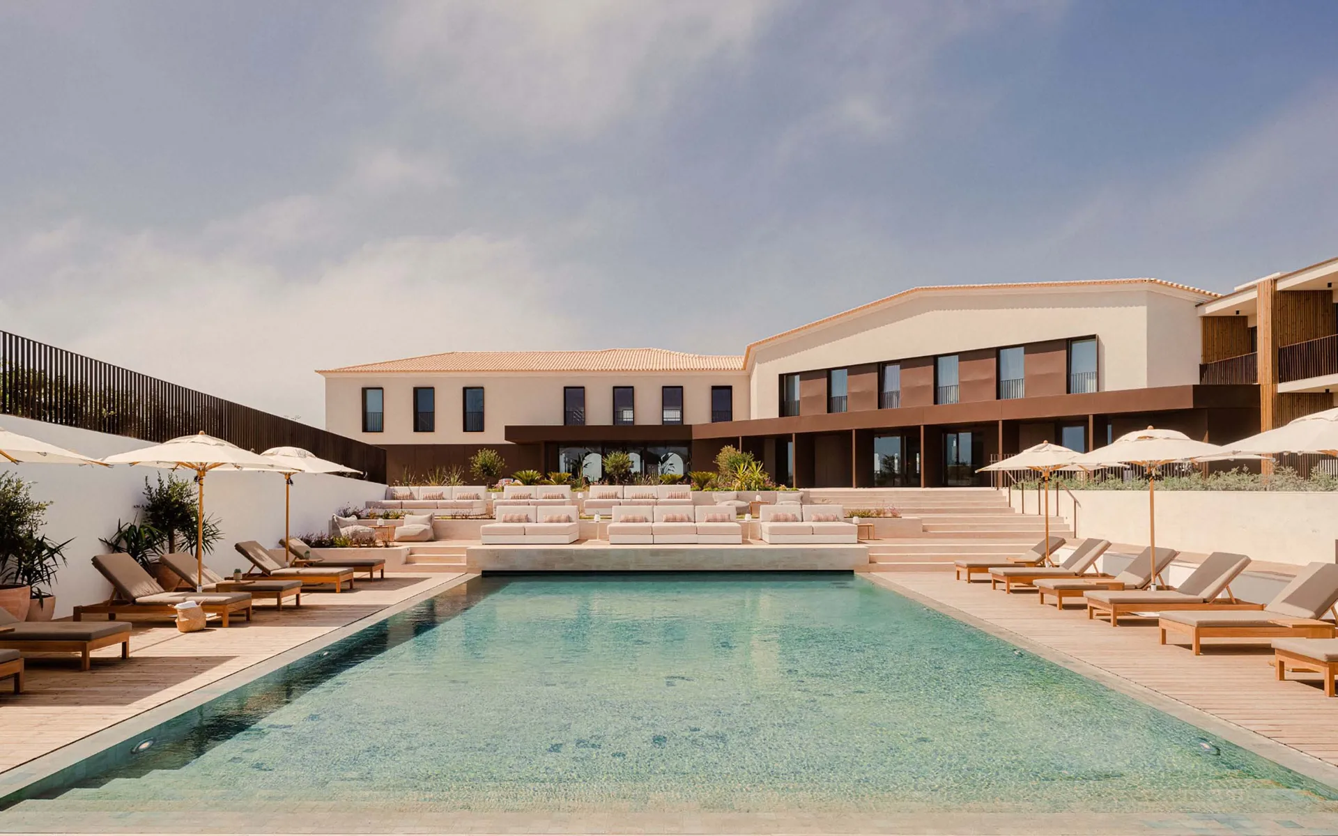 A modern resort architecture featuring a minimalist interior with concrete and wooden elements.