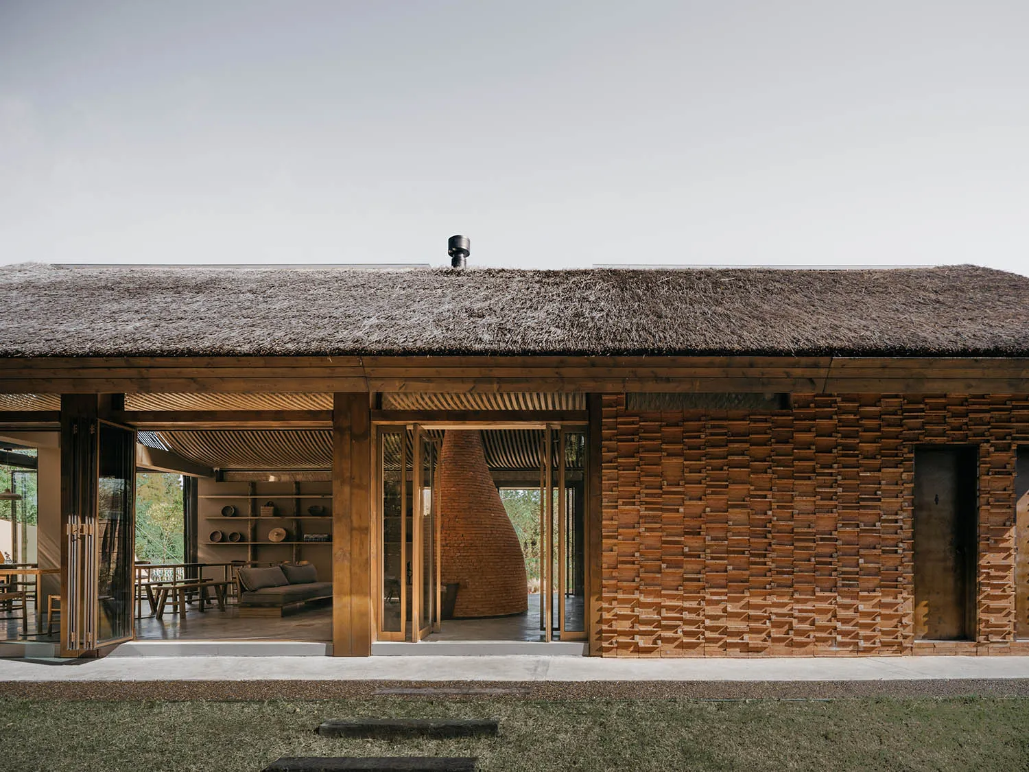 A modern residential architect with wooden walls and a thatched roof.