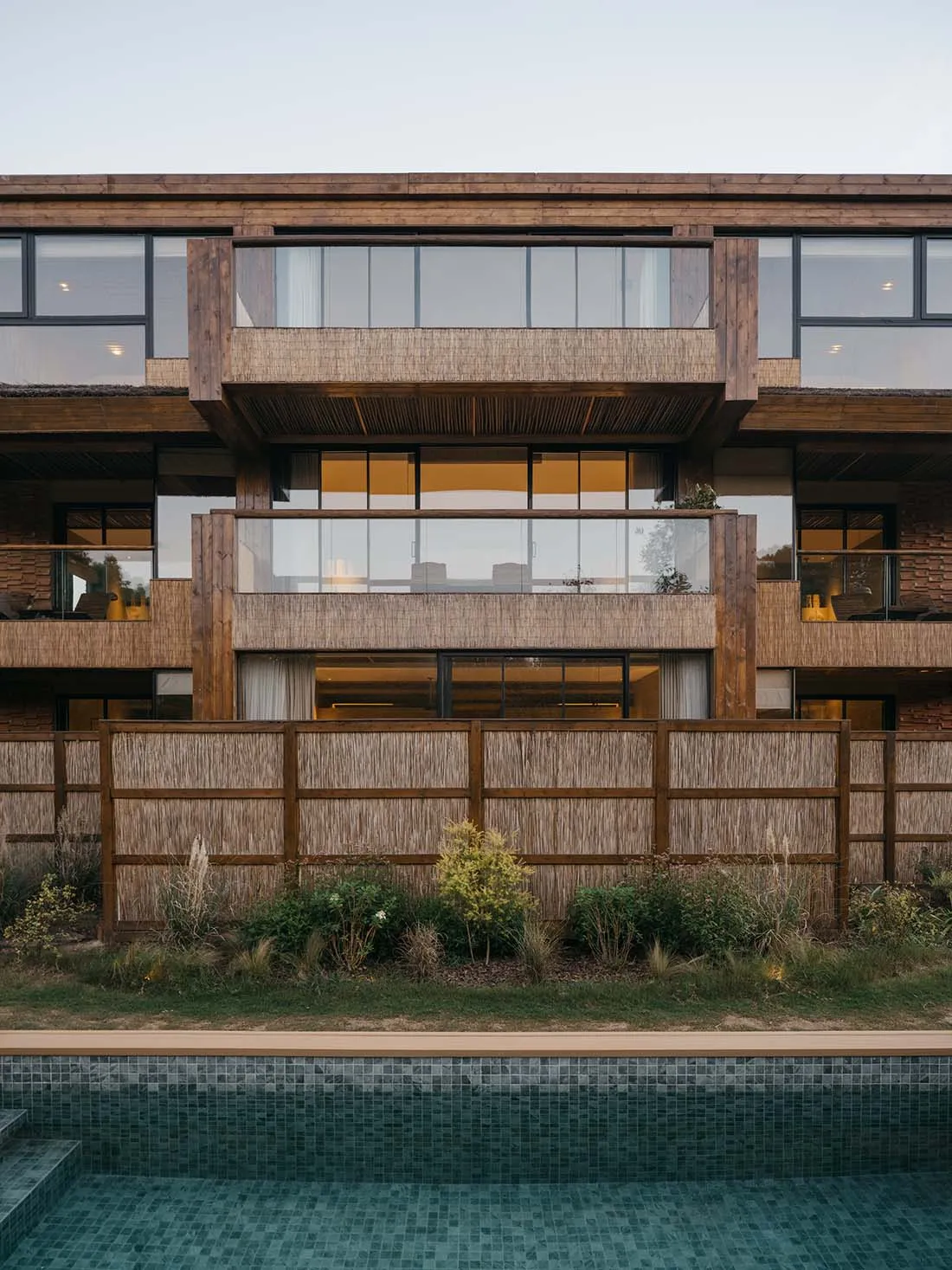 Modern residential building with large glass windows and wooden elements.