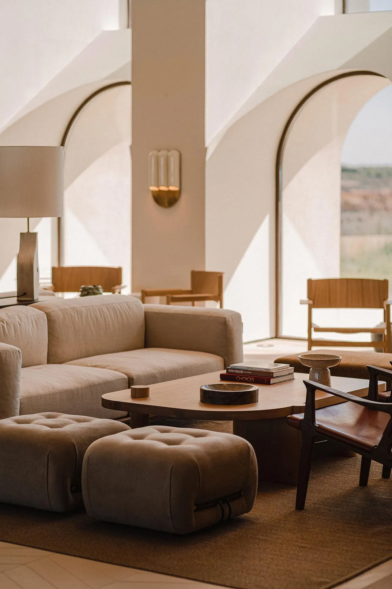 A modern living room with neutral-toned fabrics and wooden furniture, featuring a comfortable seating area and a low coffee t
