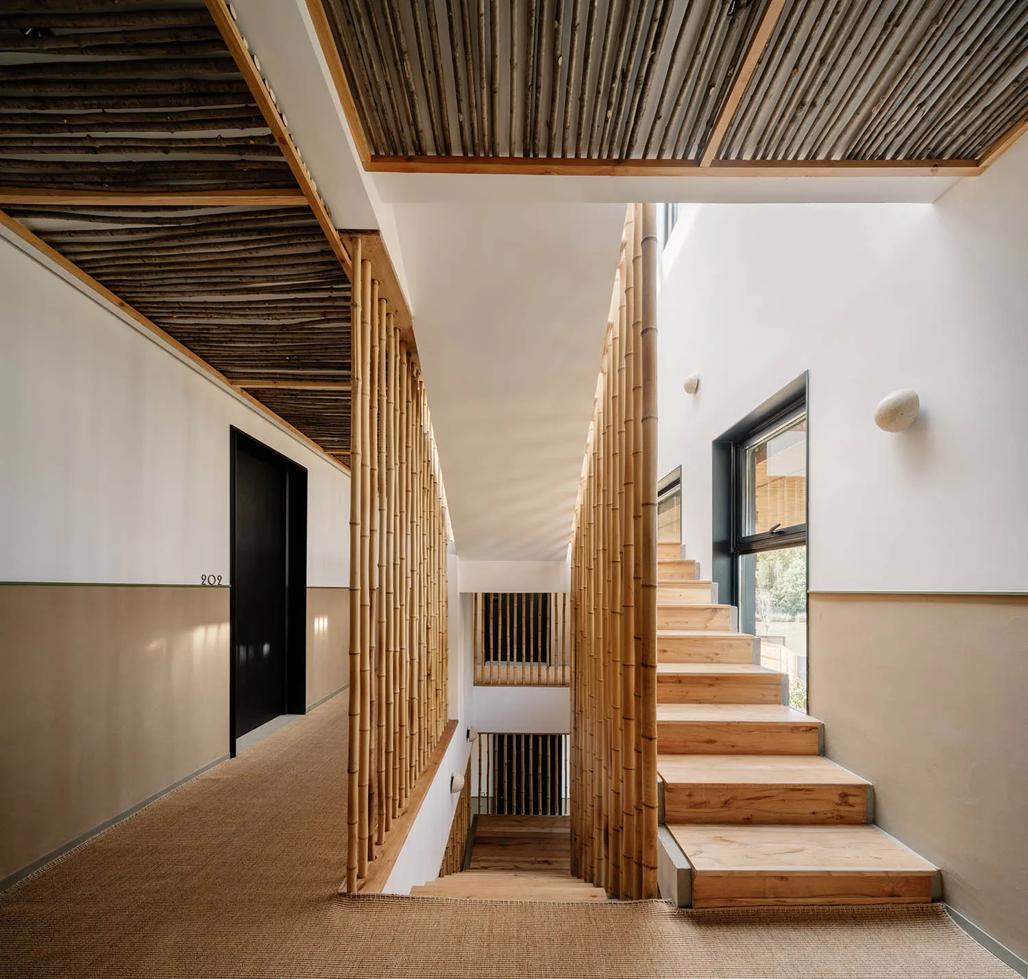 Modern staircase with bamboo railings and wooden steps in a well-lit interior space.