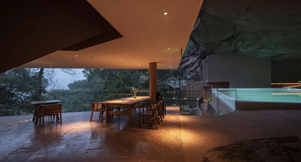 A modern living room with concrete finishes and natural lighting.