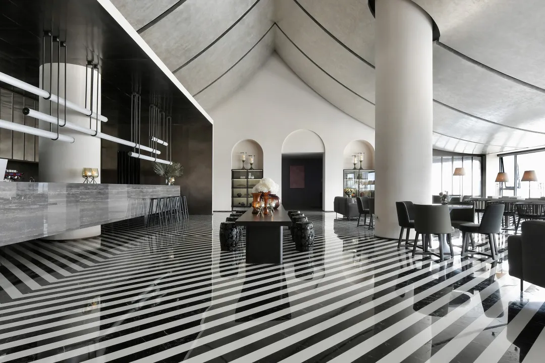 A modern restaurant with a concrete floor featuring geometric patterns.