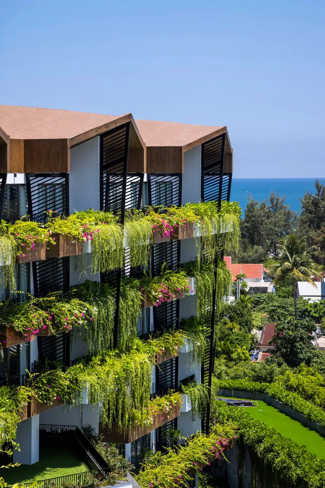 A modern building adorned with lush green plants and flowers.