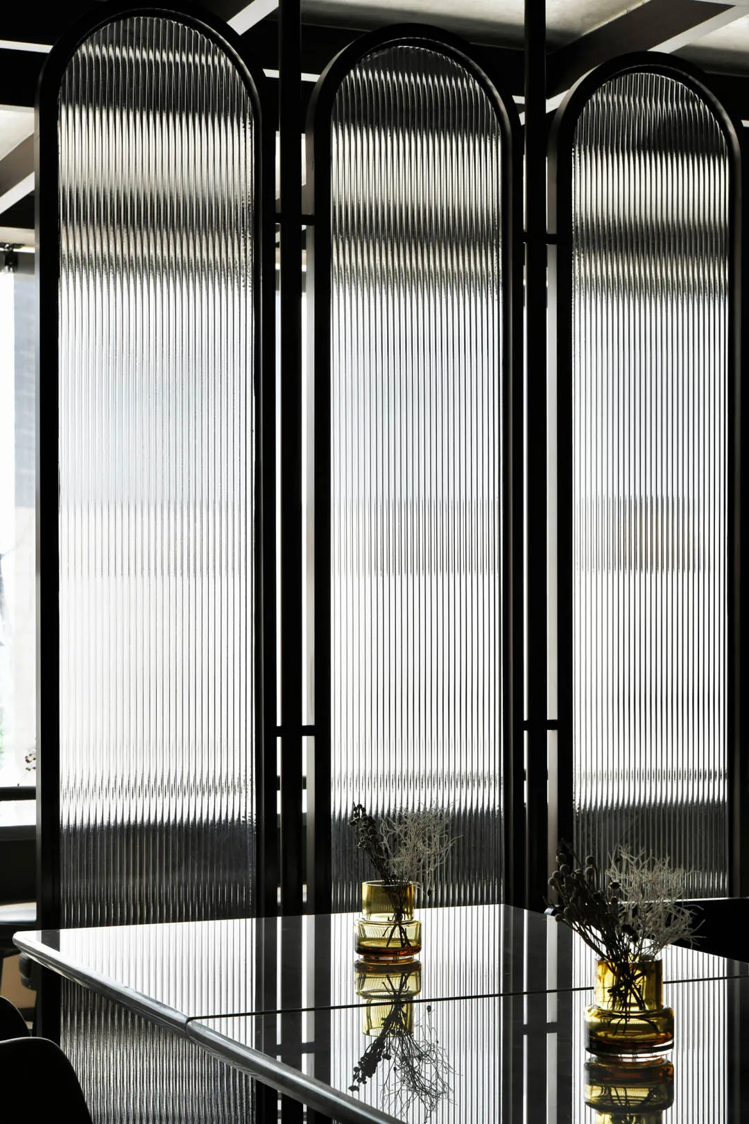 A minimalist interior design featuring a glass wall structure.
