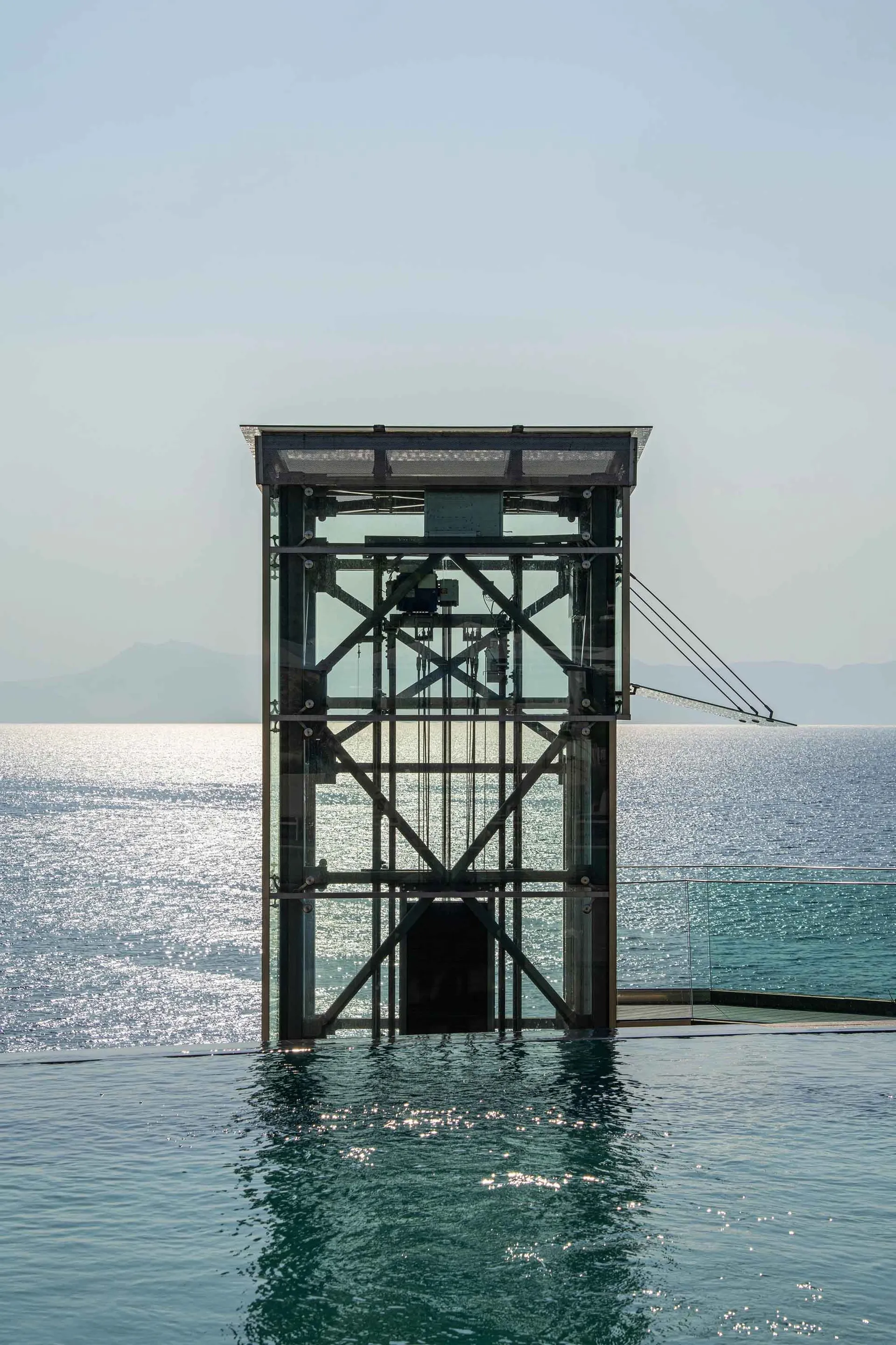 A modern glass structure emerging from the water