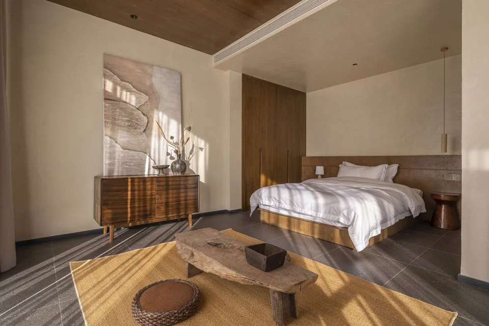 Modern minimalist bedroom featuring wooden furniture and a neutral color palette.