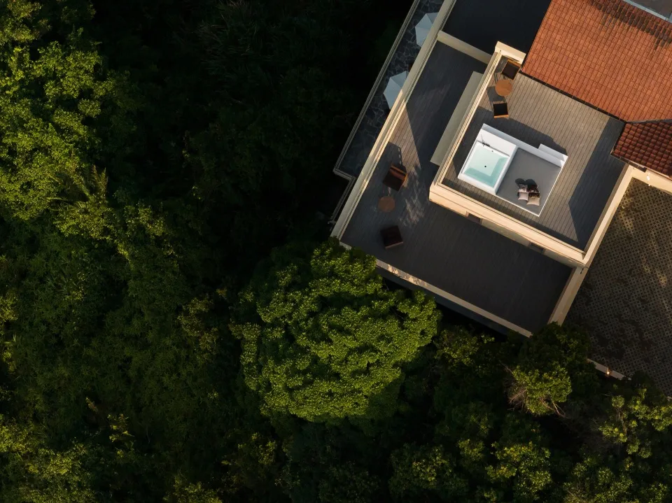 Aerial view of a rooftop terrace surrounded by lush green trees.