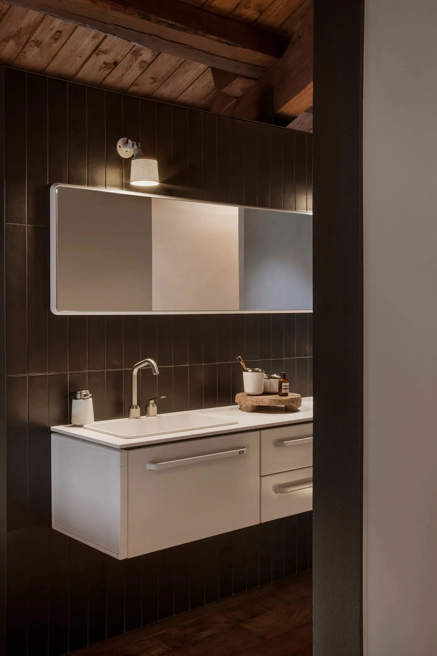 Industrial-style bathroom with metal sink, concrete tiles, and modern fixtures.
