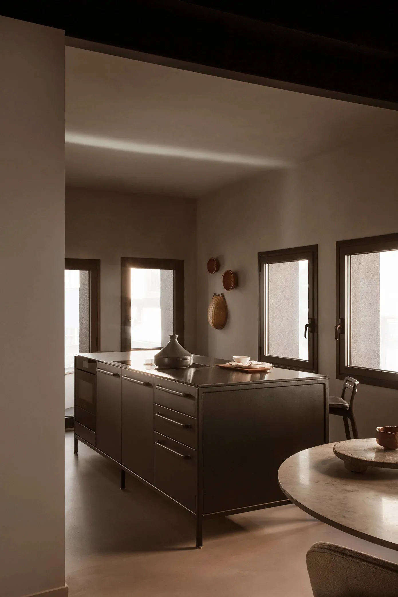 A modern, minimalist kitchen featuring a metal kitchen island.