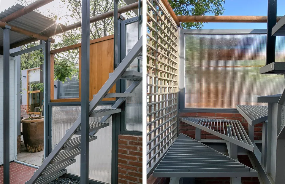 Metal stairway with industrial design elements in an outdoor setting.