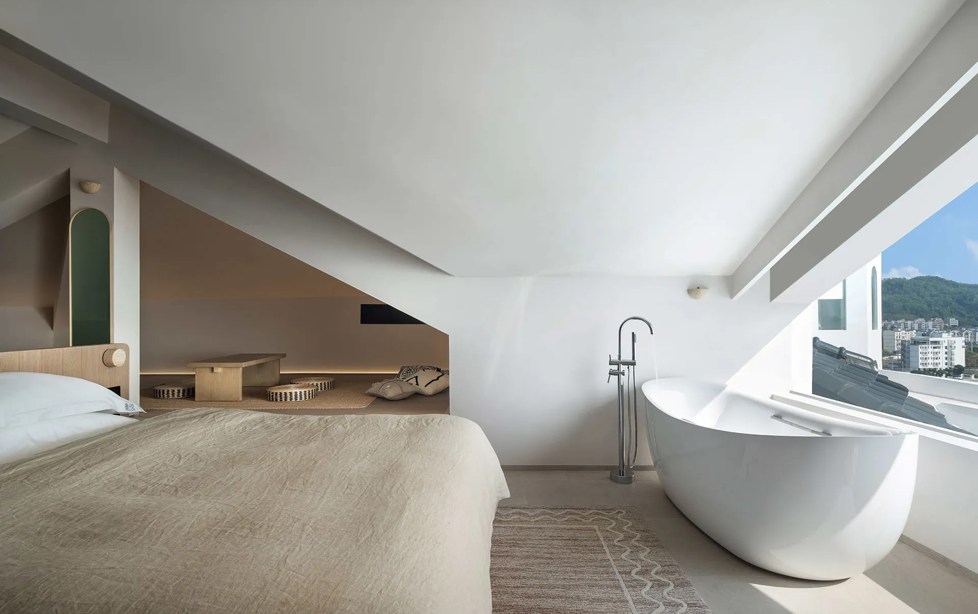Modern minimalist bedroom with white concrete walls and floor, large window with city view.