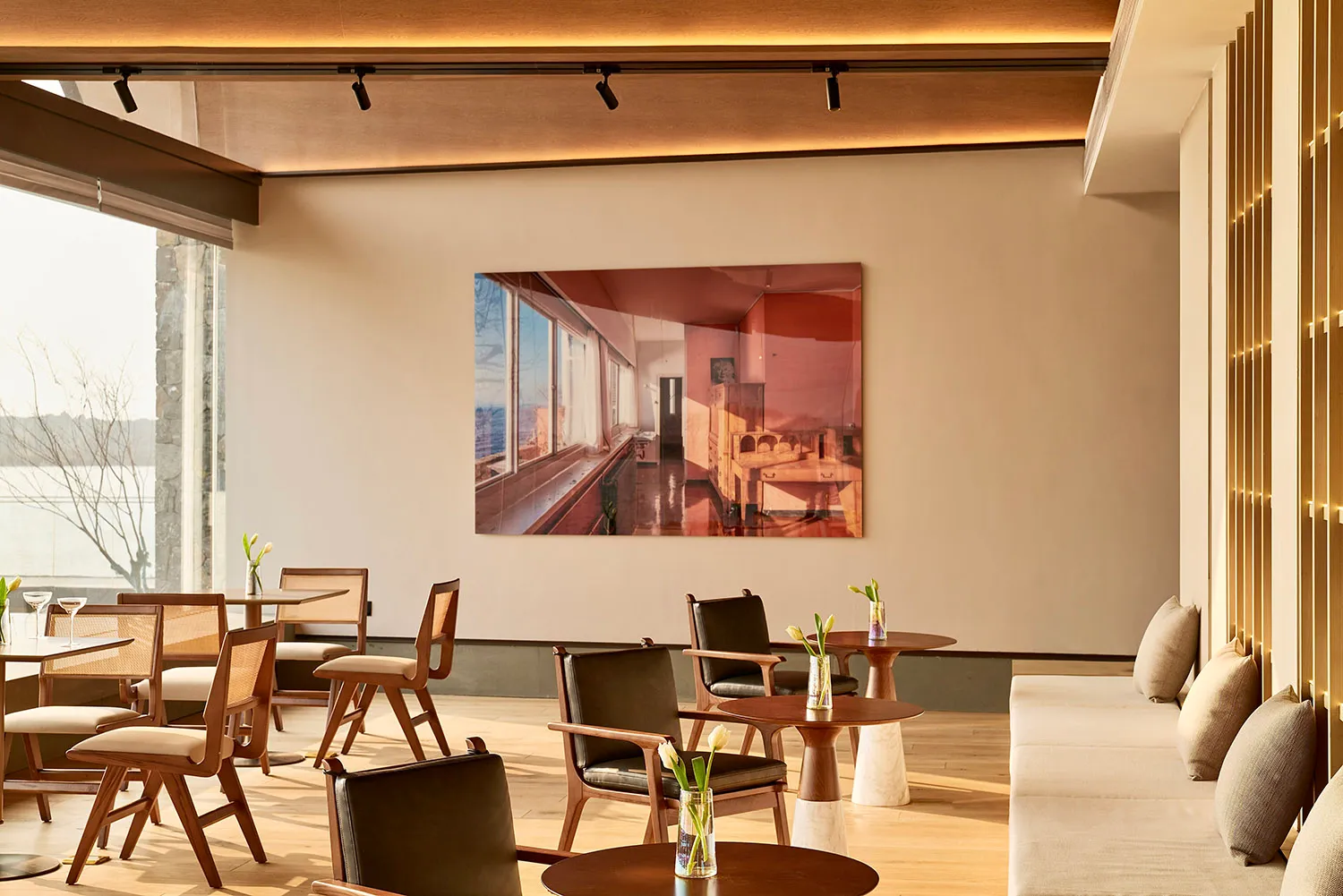 現代餐廳吧台室內,搭配木質家具、餐桌與座椅,牆面懸掛大型裱框照片。