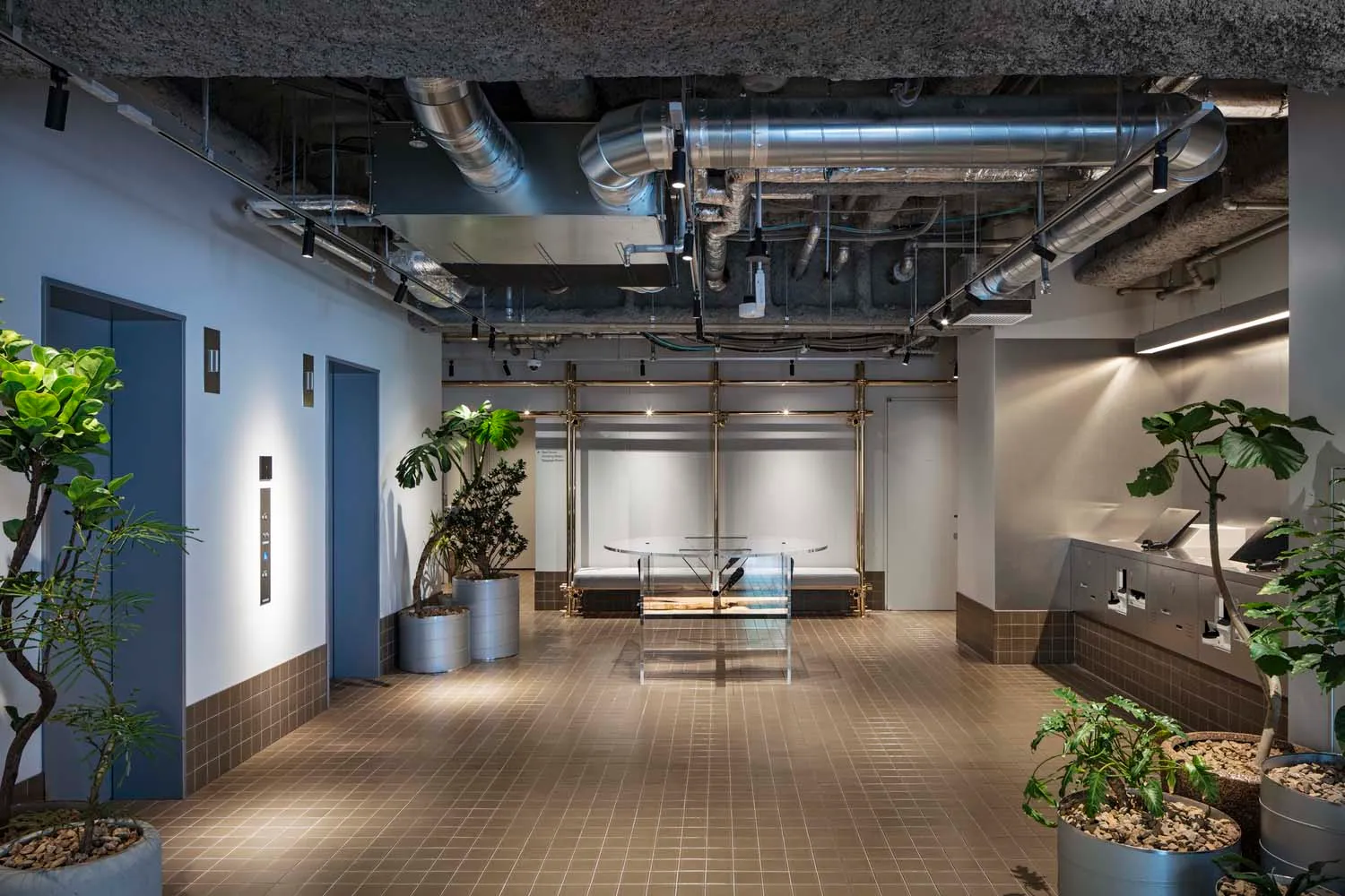 工業風辦公大廳採用混凝土與鋼材,展現現代設計,露出天花板管線與平台