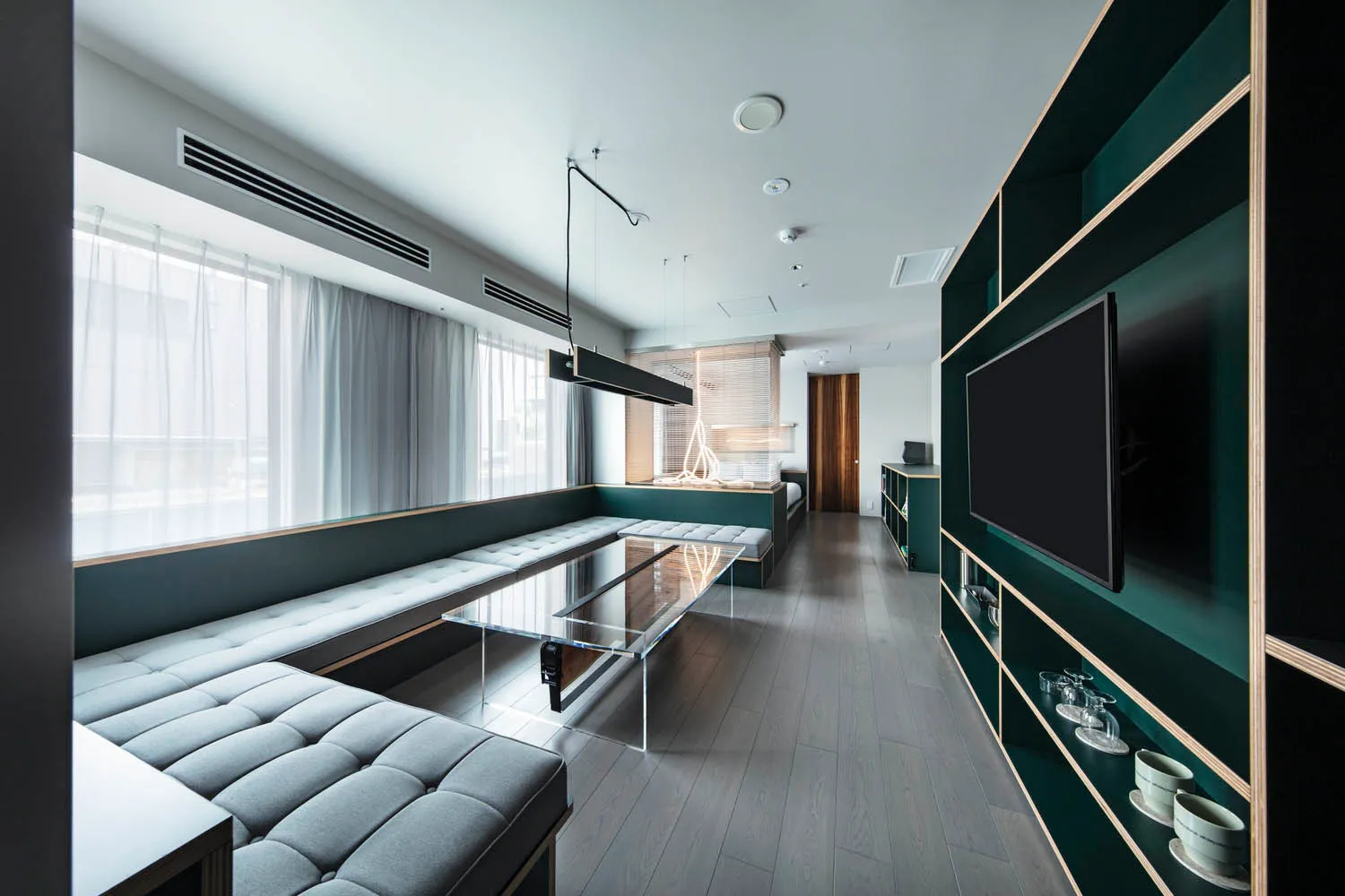 Modern living room featuring a clear glass table, contemporary furniture, and minimalist decor.