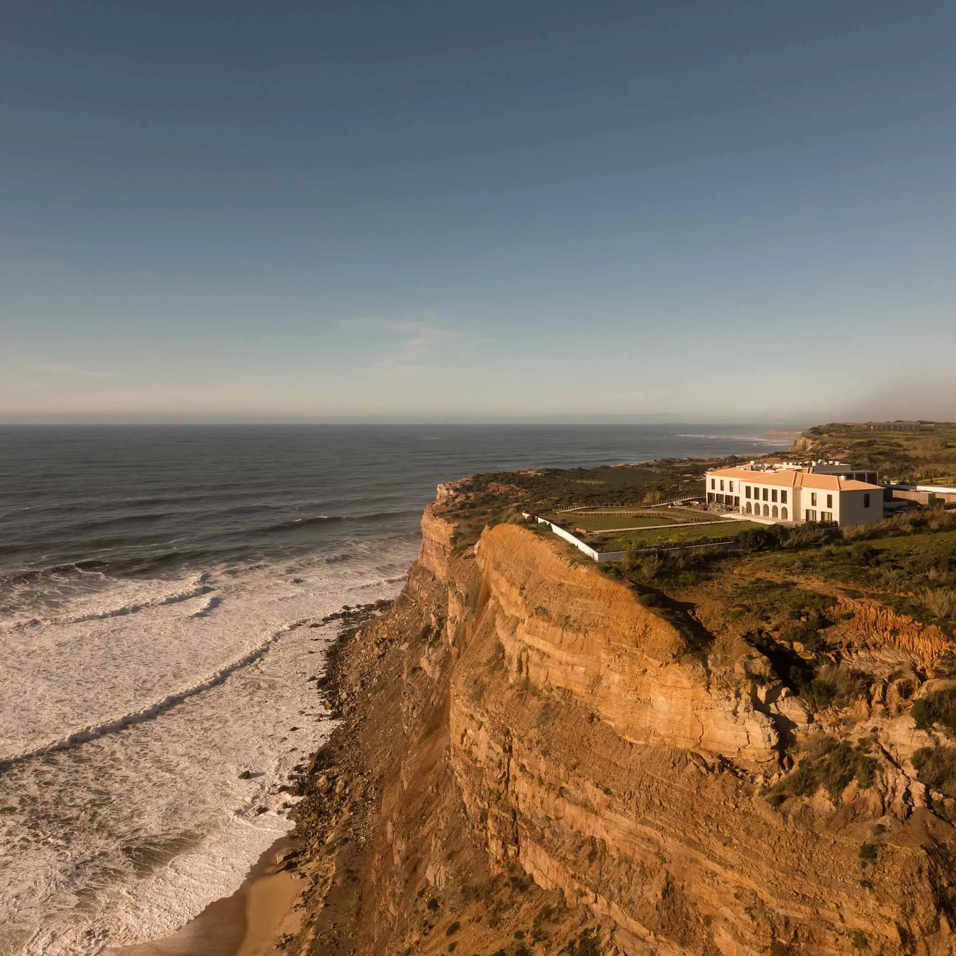 Cliffside vacation resort on a beautiful coastal landscape, featuring luxurious accommodations and breathtaking ocean views.