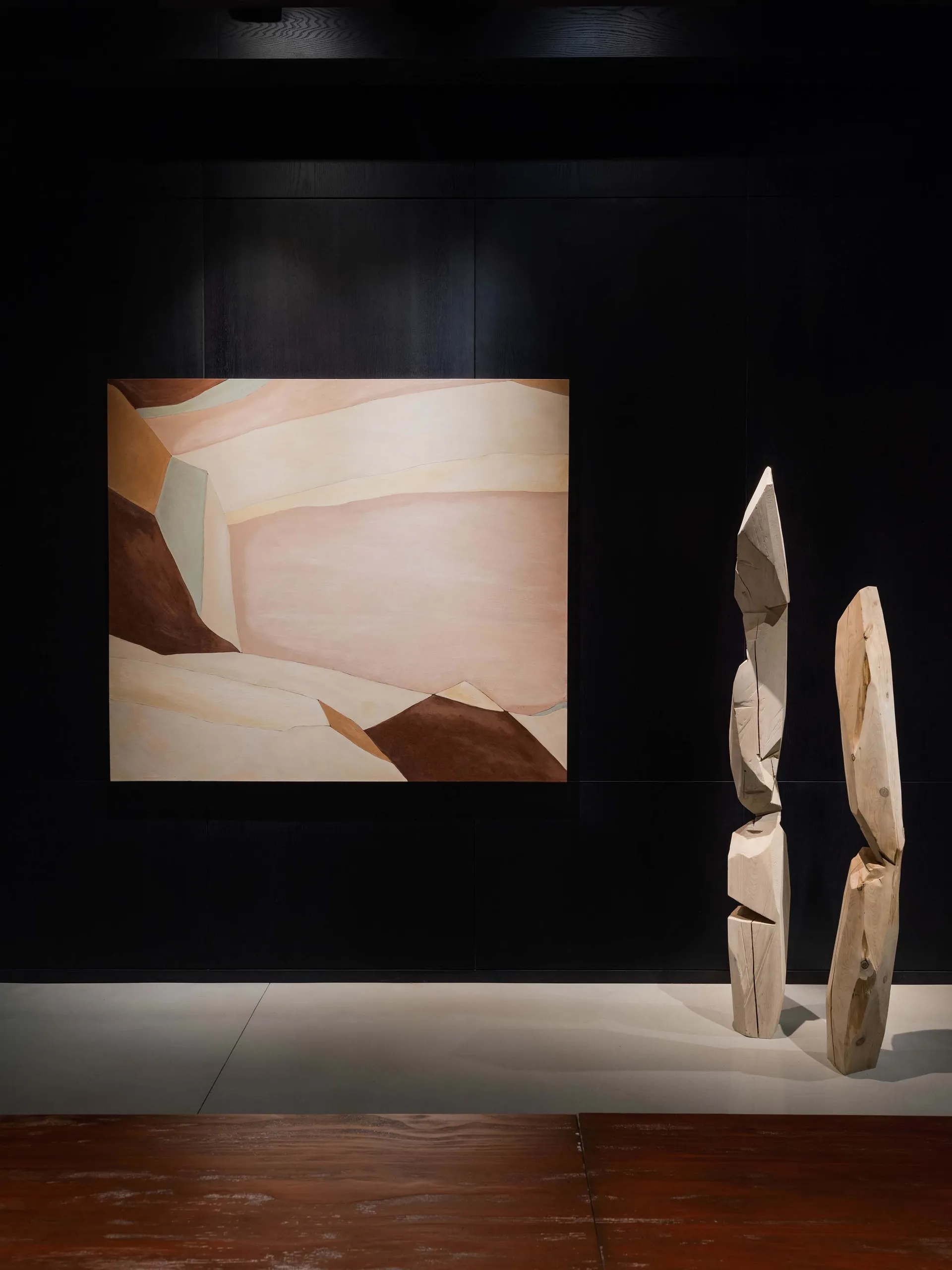 A modern abstract sculpture created from wood, featuring geometric shapes and organic forms.