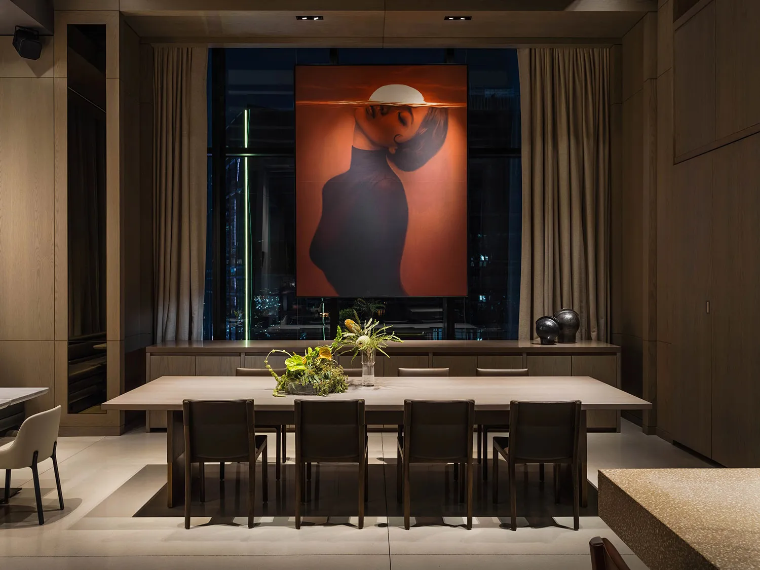 Modern dining room featuring timber chairs and table, glass windows, and concrete flooring.