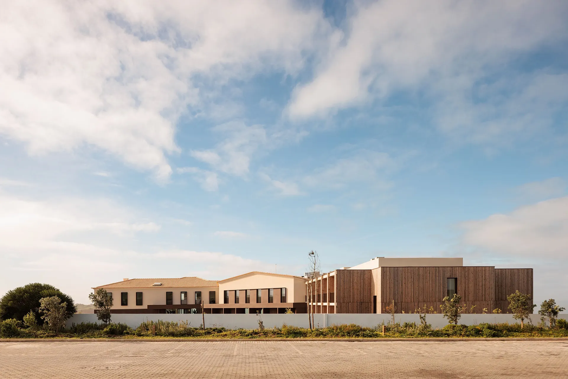 Modern institutional building with brick and wooden exterior materials.