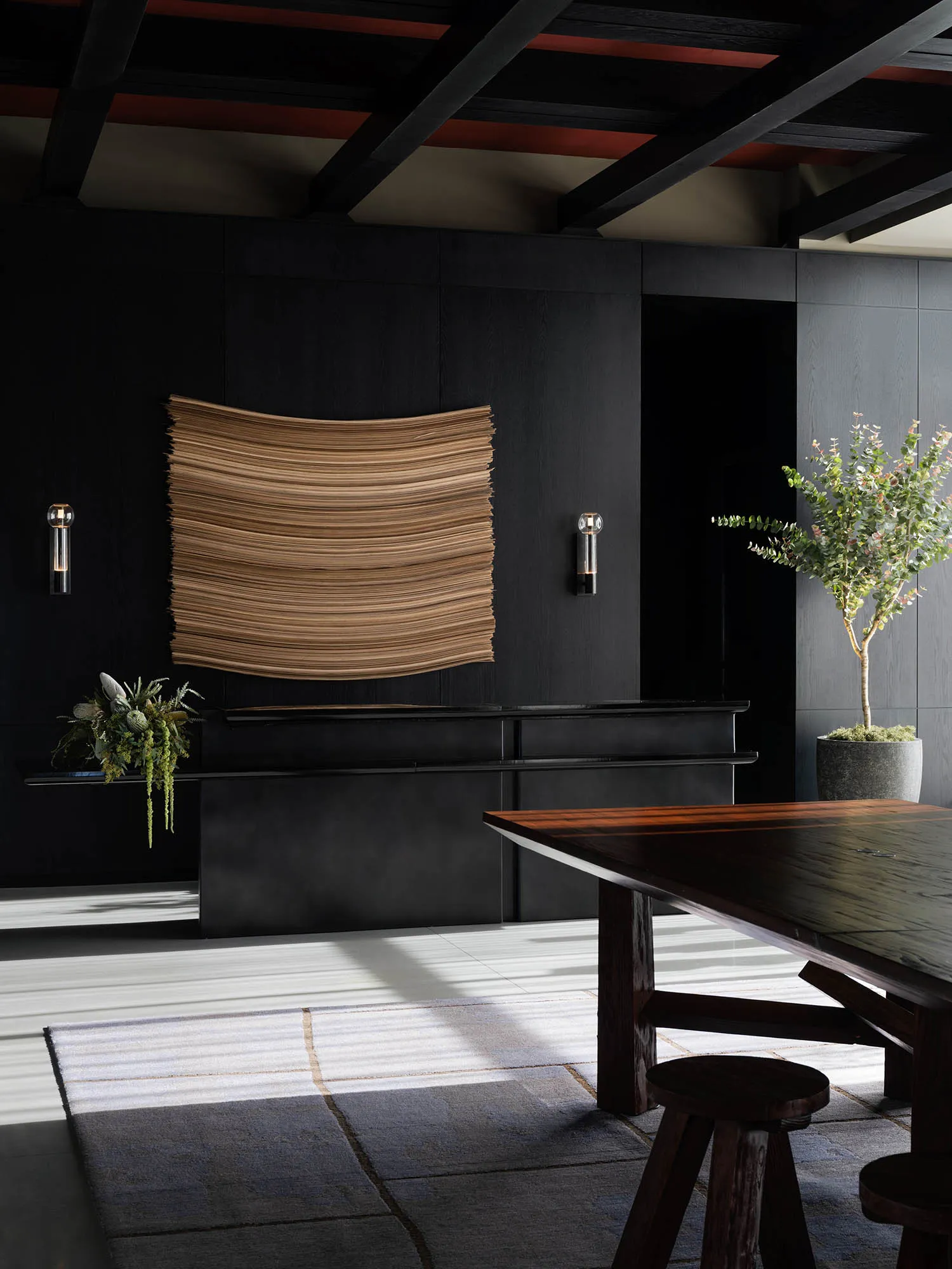 A modern living room featuring wooden furniture, a large window, and a vase with flowers.