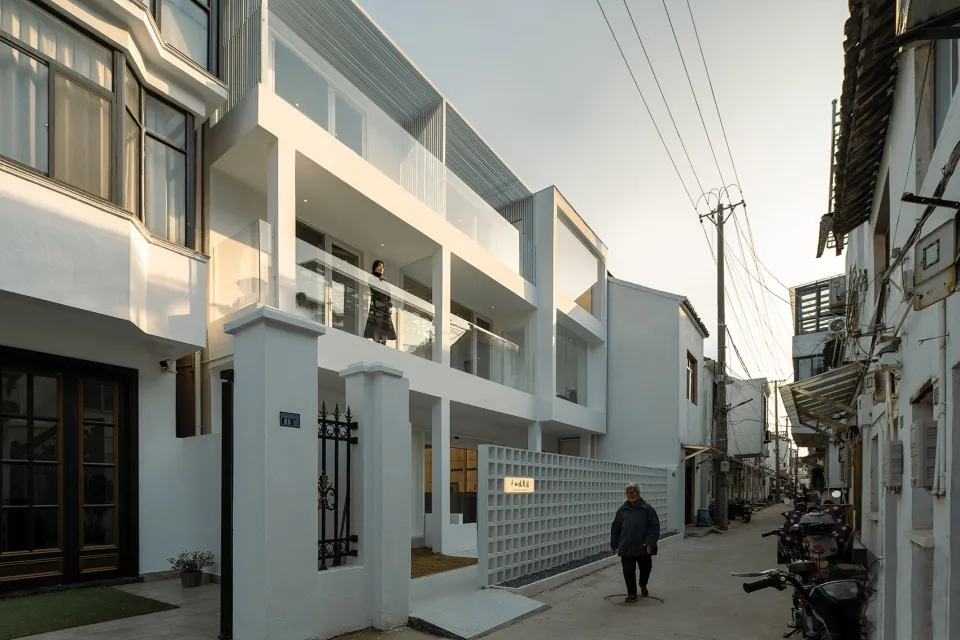 現代住宅建築,擁有白色牆面、玻璃窗以及金屬欄杆與門。