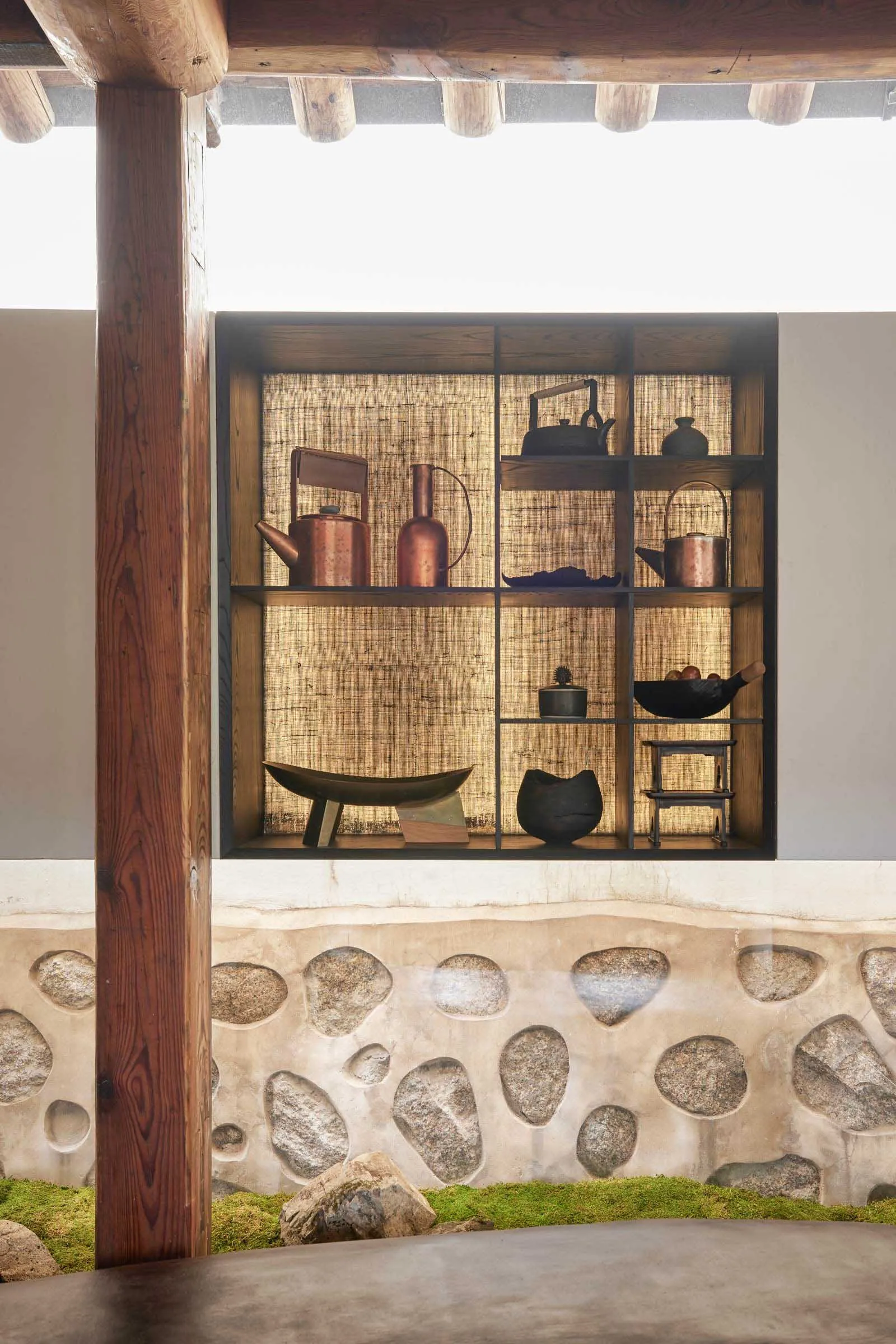 A traditional interior design featuring wooden shelves adorned with various decorative items, including teapots, bottles, bow