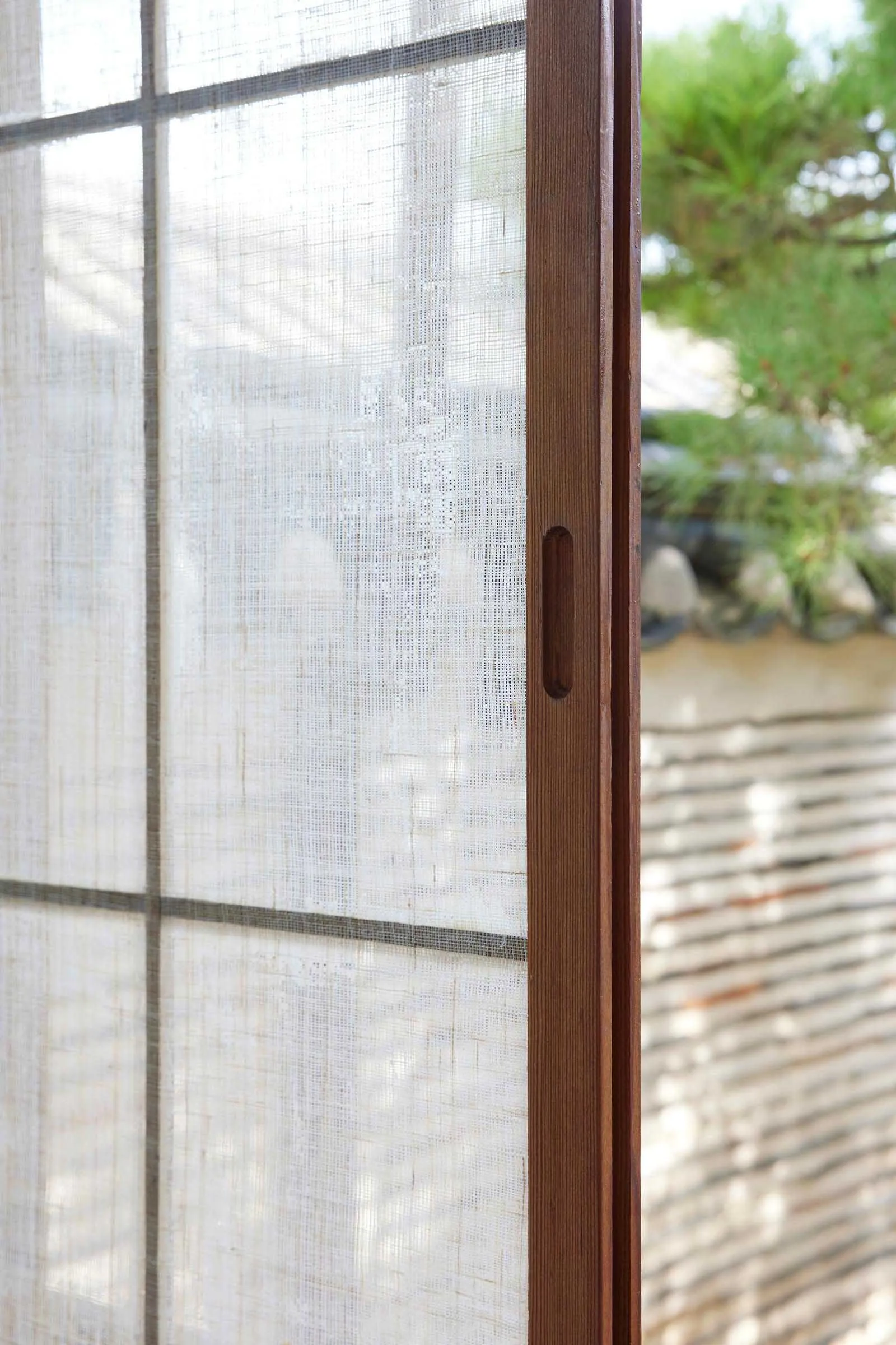 A close-up of a traditional window with a wooden frame, showcasing the texture and craftsmanship.