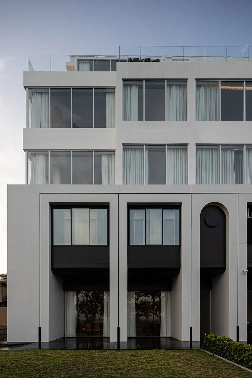 Modern building with concrete facade and large windows.