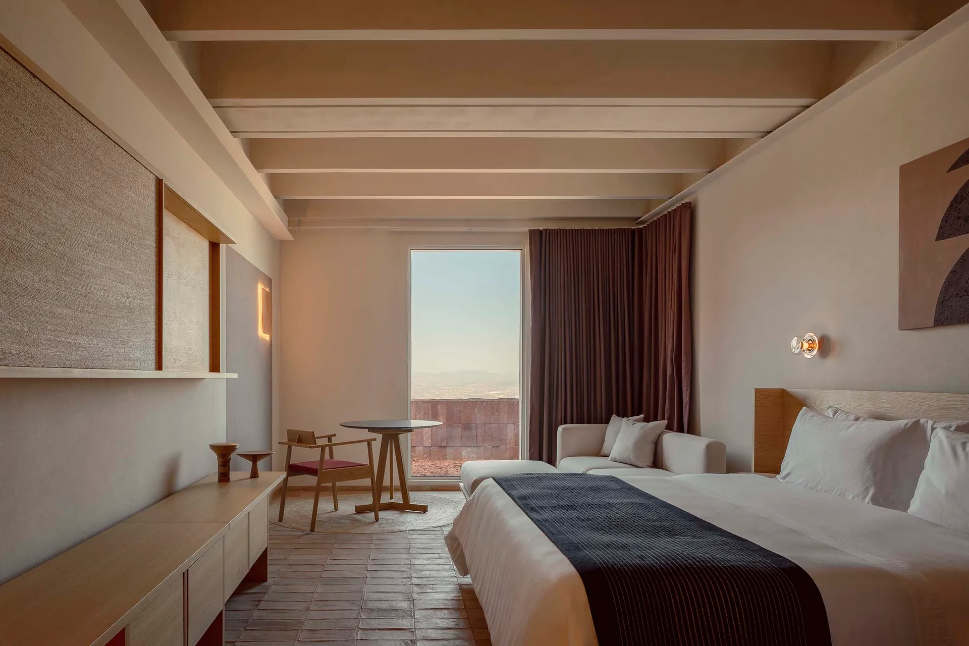 A minimalist bedroom featuring wooden furniture and textile accents.