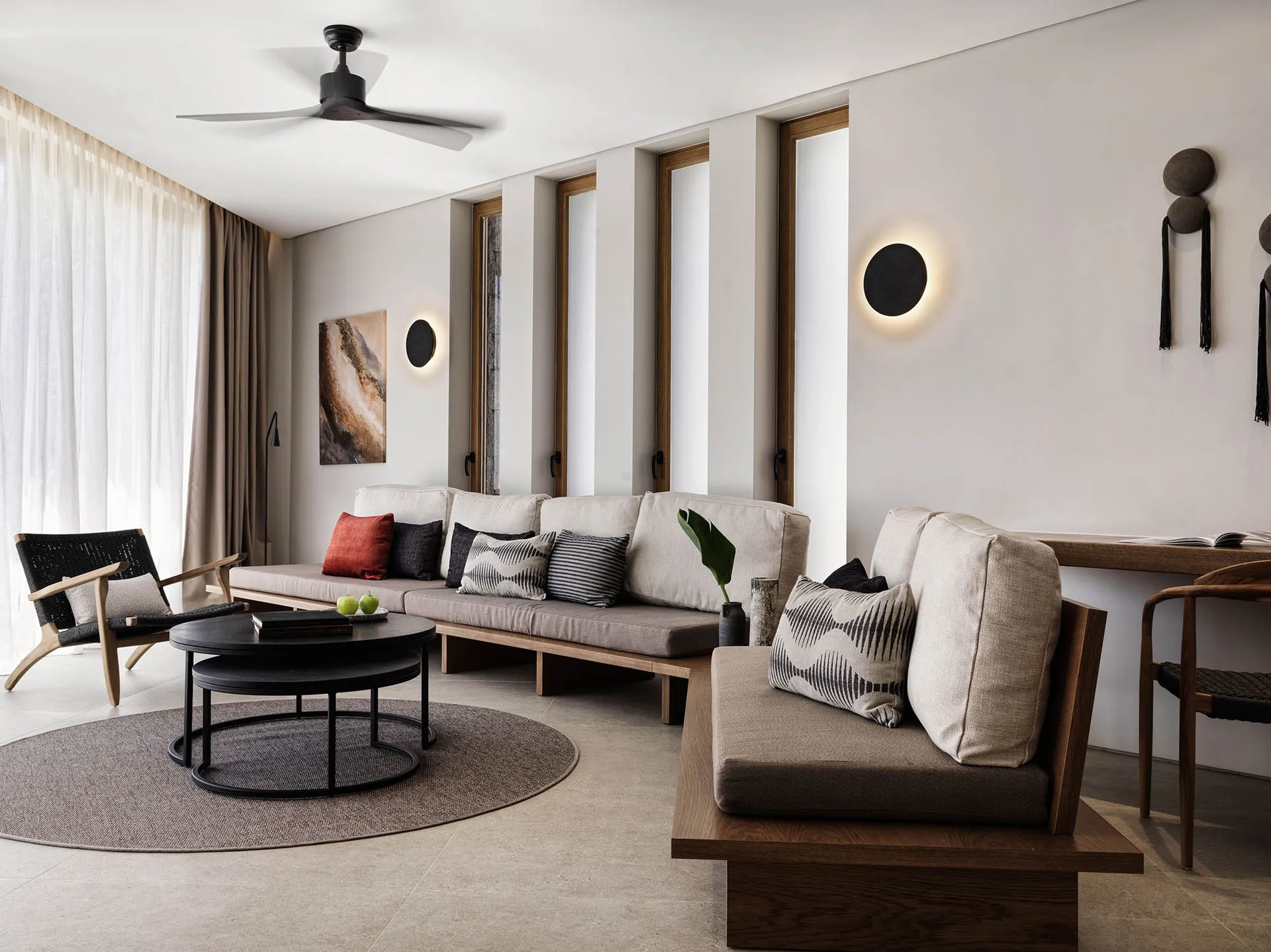A minimalist living room with modern interior design, featuring wooden furniture, concrete accents, and leather upholstery.